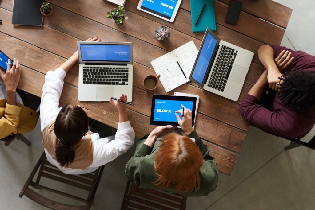 a birds-eye view of a group of people working remotely on laptops.